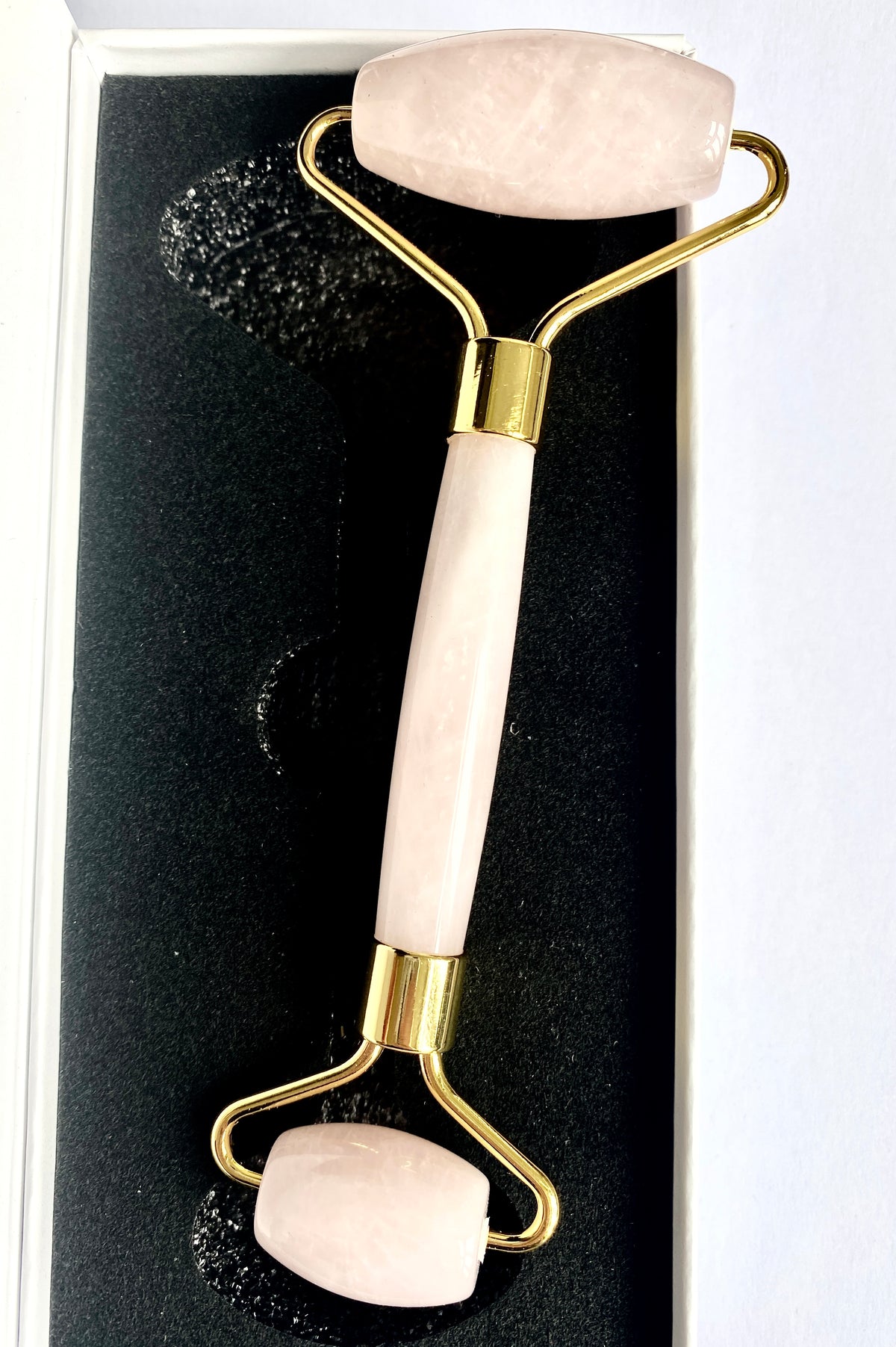 Dual-ended rose quartz facial roller in presentation box